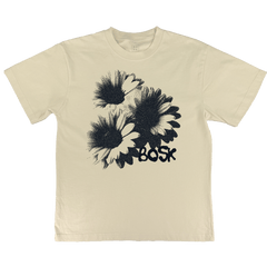 The BOSK Floret Tee is a cream heavyweight cotton t-shirt with a black stippled illustration of three overlapping daisies and "BOSK" in bold below. It offers an oversized fit and is available in men's sizing.