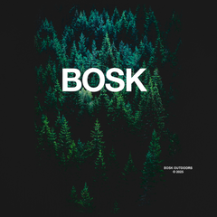 An aerial view of a dense green forest under dim light fills the image. Large white text in the center reads “BOSK.” In the lower right, “Forest Brush Tee, BOSK © 2023” notes this classic fit tee is crafted from heavy-weight cotton.