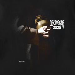 A person in a dark robe holds a golden mask against black, wearing the St. Francis Tee by BOSK—a classic fit, heavy-weight 100% cotton shirt. "LOSK 2025" is boldly above; "BOSK © 2025" at the lower left. Light emphasizes the hands and mask.