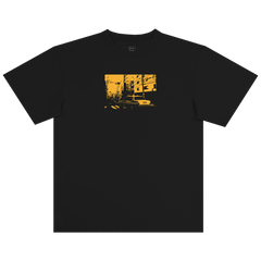 The BOSK Yellow Cab Tee is a classic fit, heavy-weight black t-shirt made from 100% cotton, featuring a bold yellow chest graphic of an urban street scene with buildings, power lines, and a car.